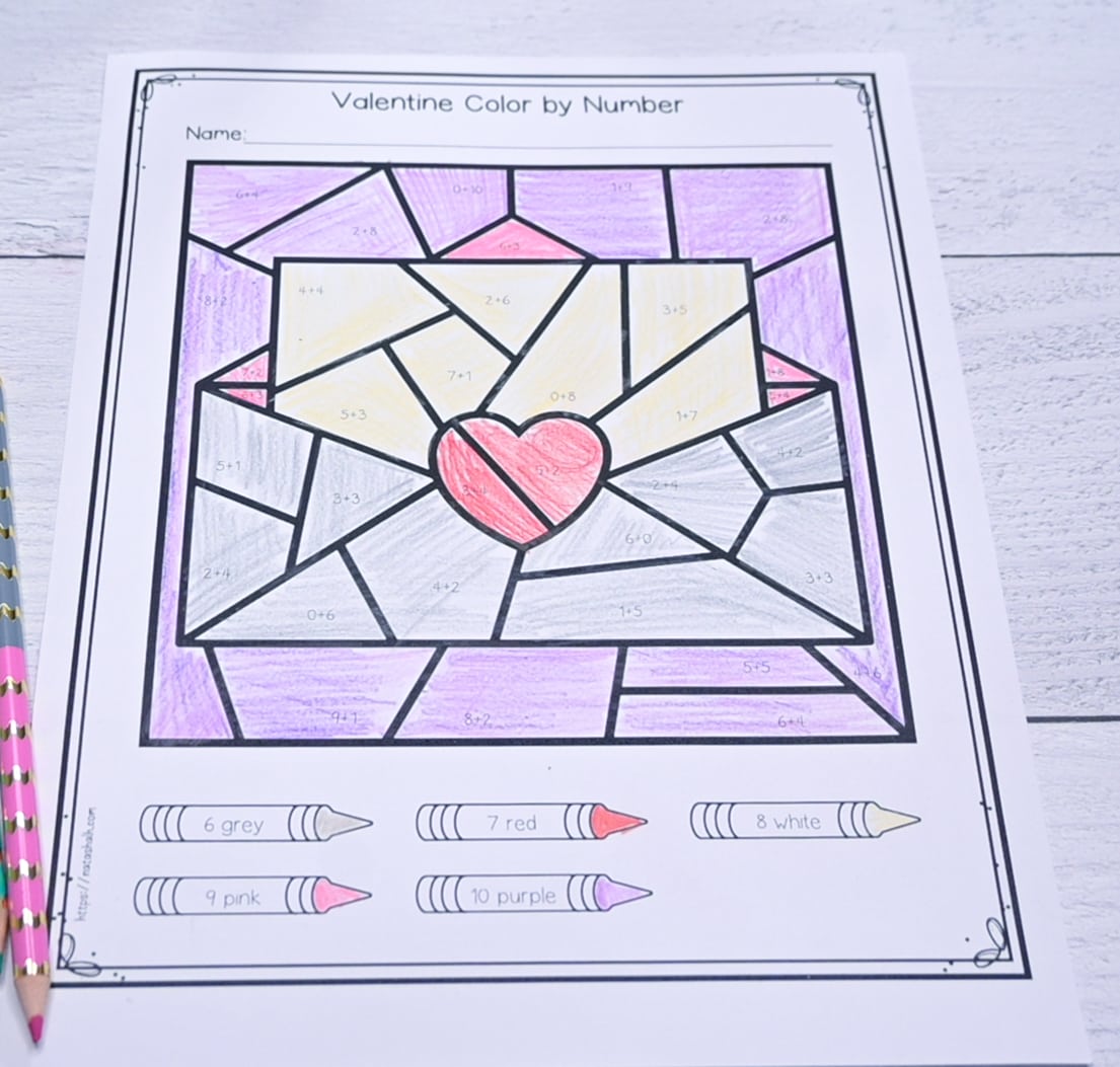 A photograph of a completed color by addition page for Valentine's Day with math facts for 6-10