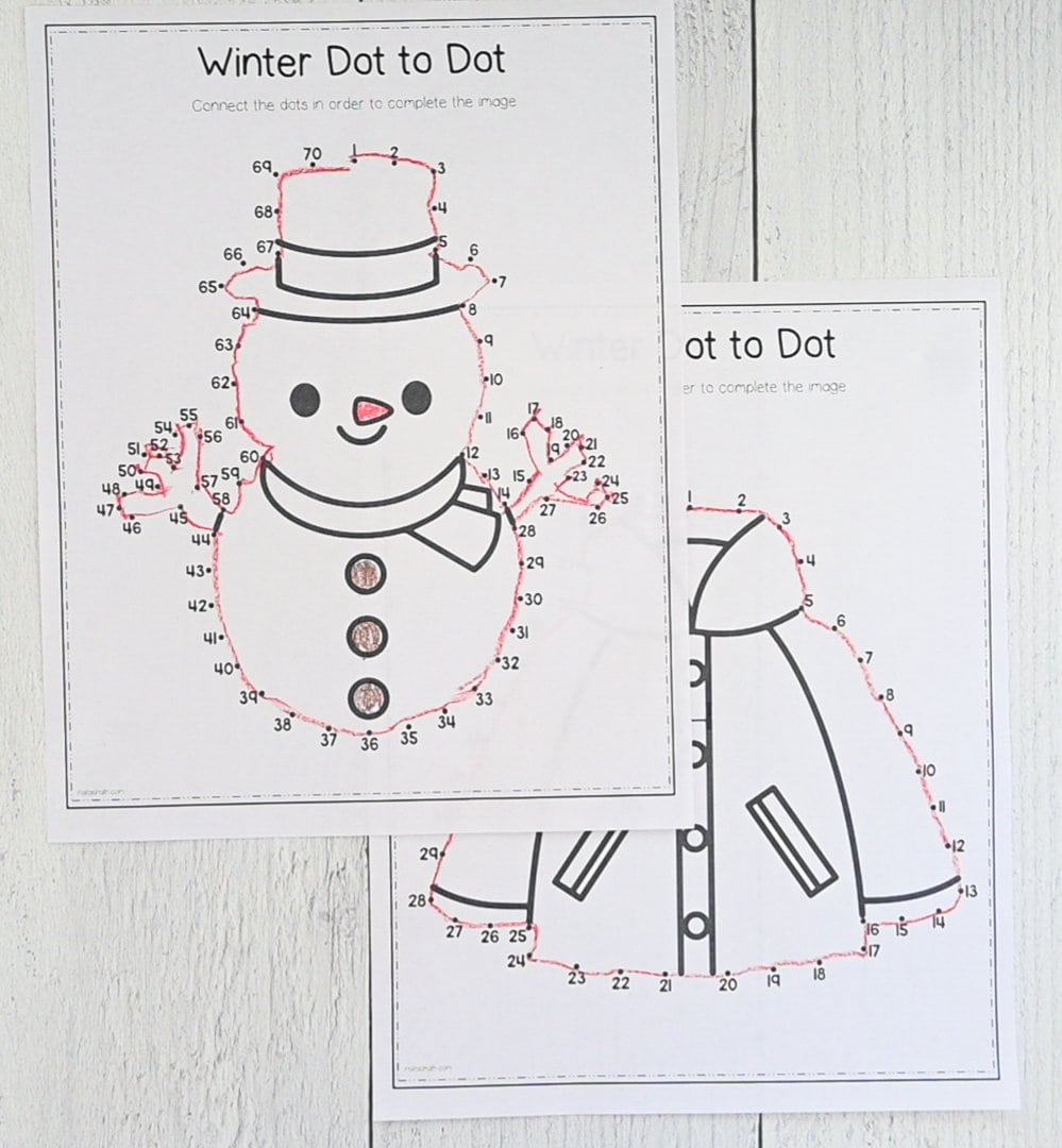 A top down picture of two easy dot to dot images - one with a snowman and one with a coat - that have been completed with red crayon