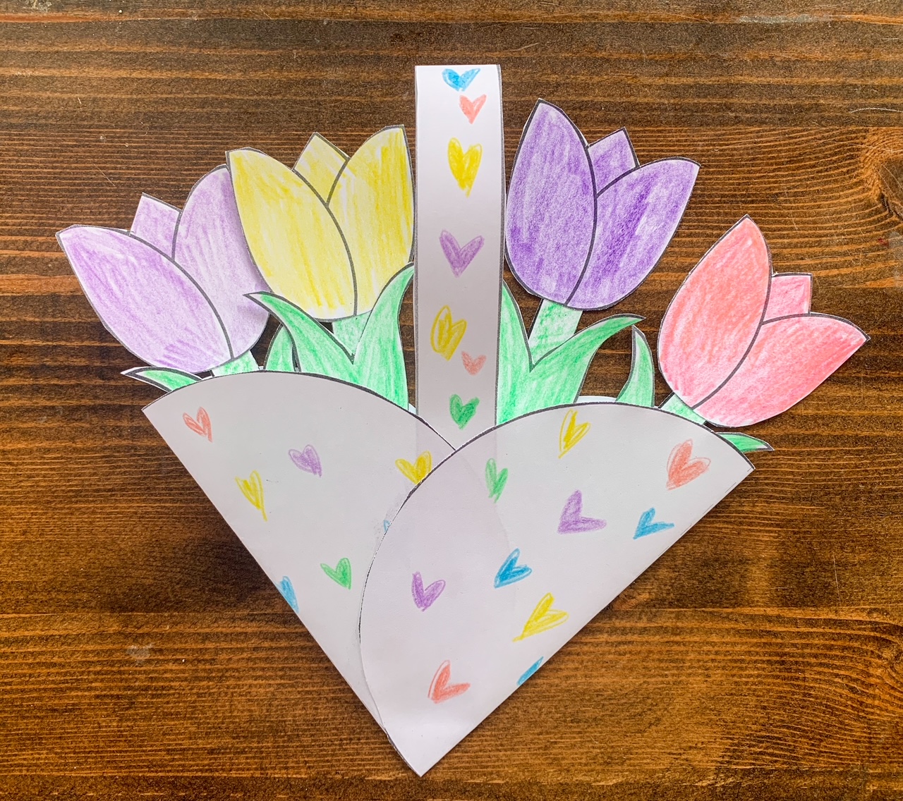 A paper basket with four paper tulips
