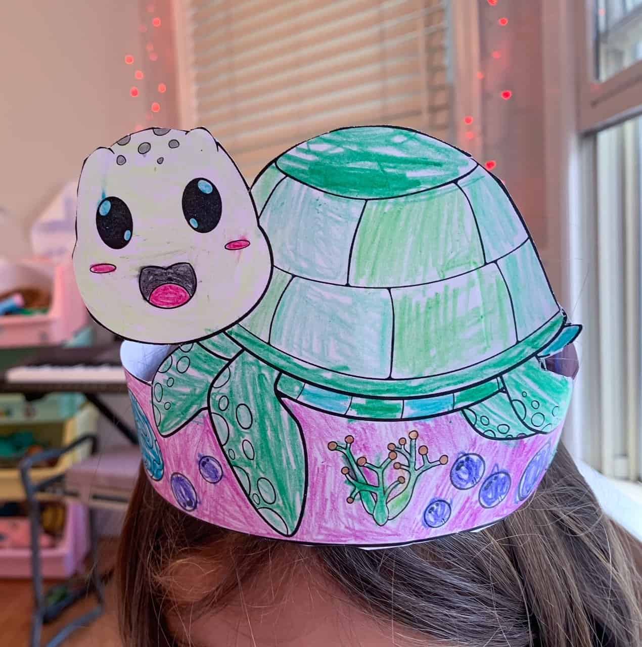 A completed sea turtle headband craft being worn on a girl's head