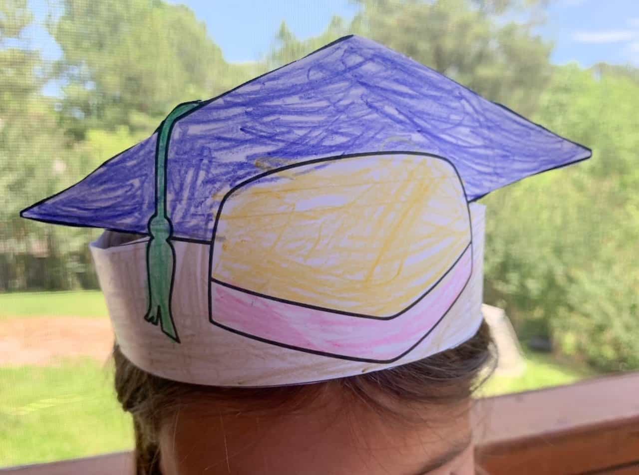 A child's head waring a colorful graduation cap crown craft