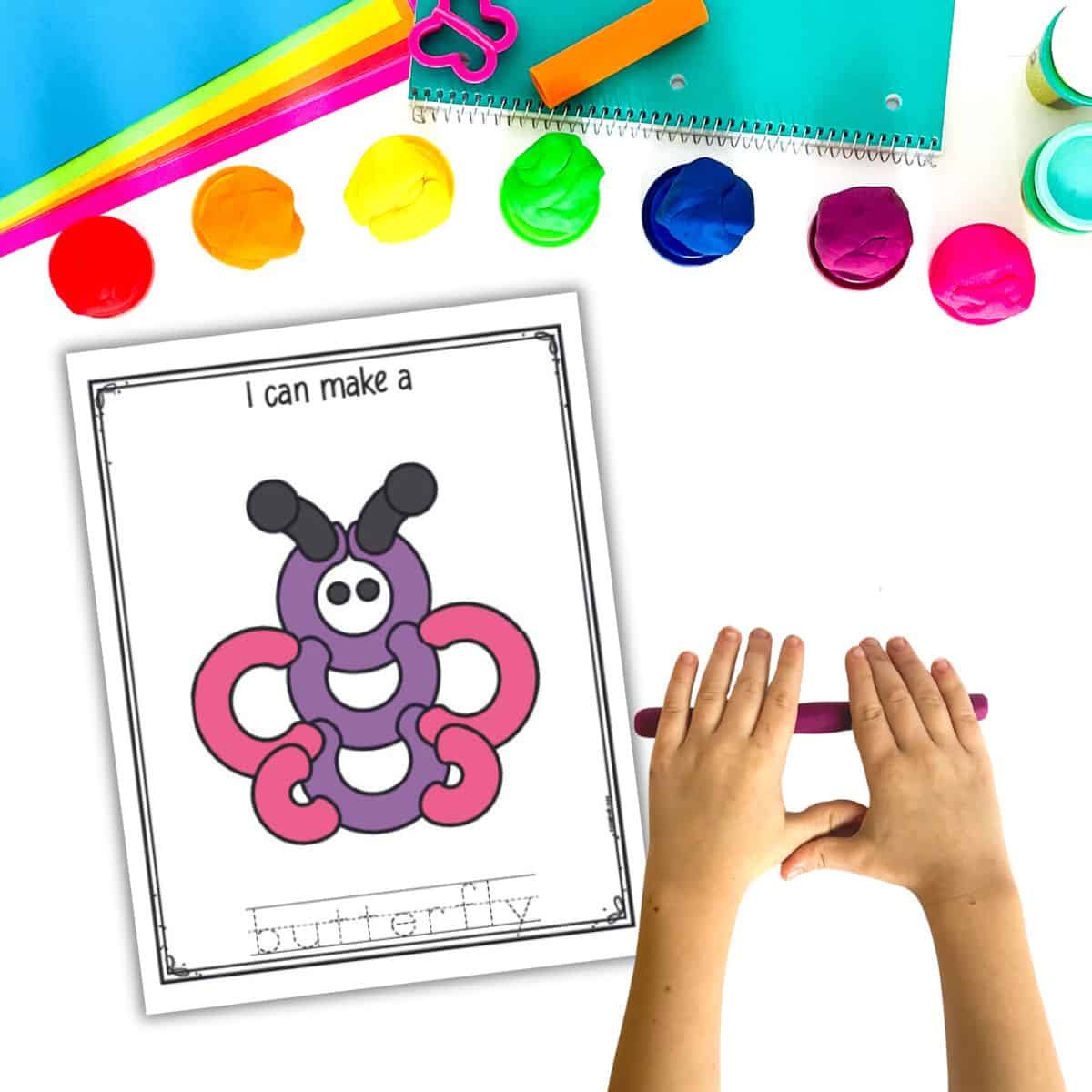 A play dough mat with a butterfly shown with containers of play dough a pair of hands rolling out a play dough snake