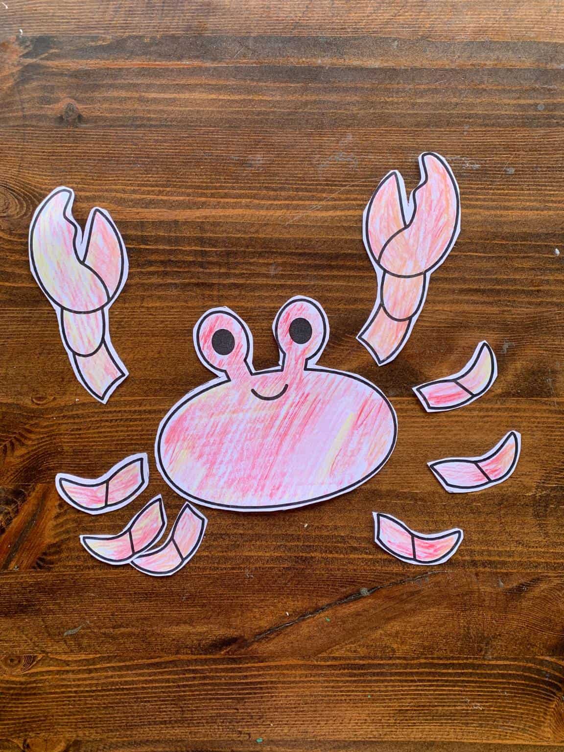 A colored and cut out, but not glued, cut and paste crab craft for kids