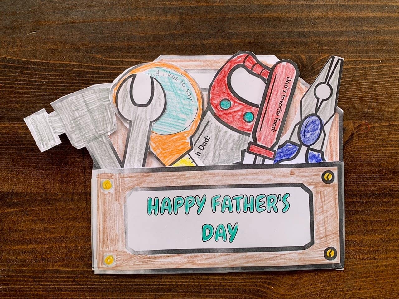 A photo of a Father's Day card craft shaped like a toolbox with tools