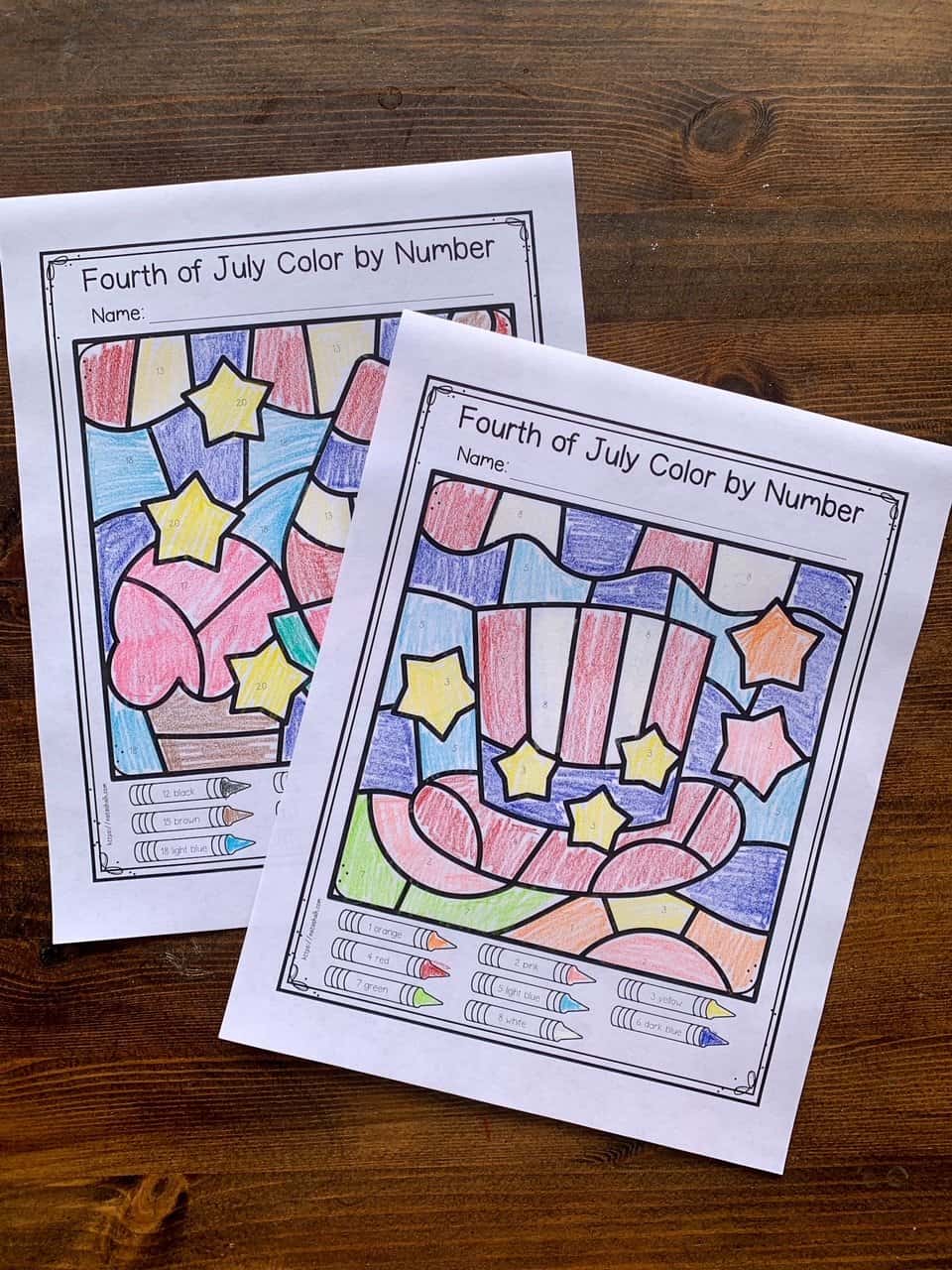 A photograph of two completed Fourth of July color by number pages for kids