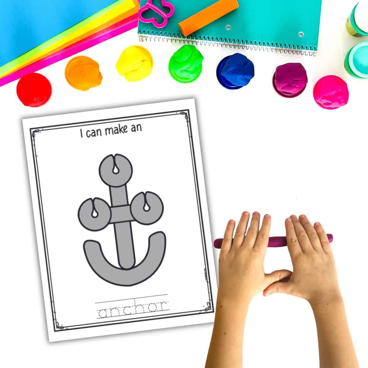 A top down image of a play dough mat with an anchor and child's hands rolling out a play dough snake