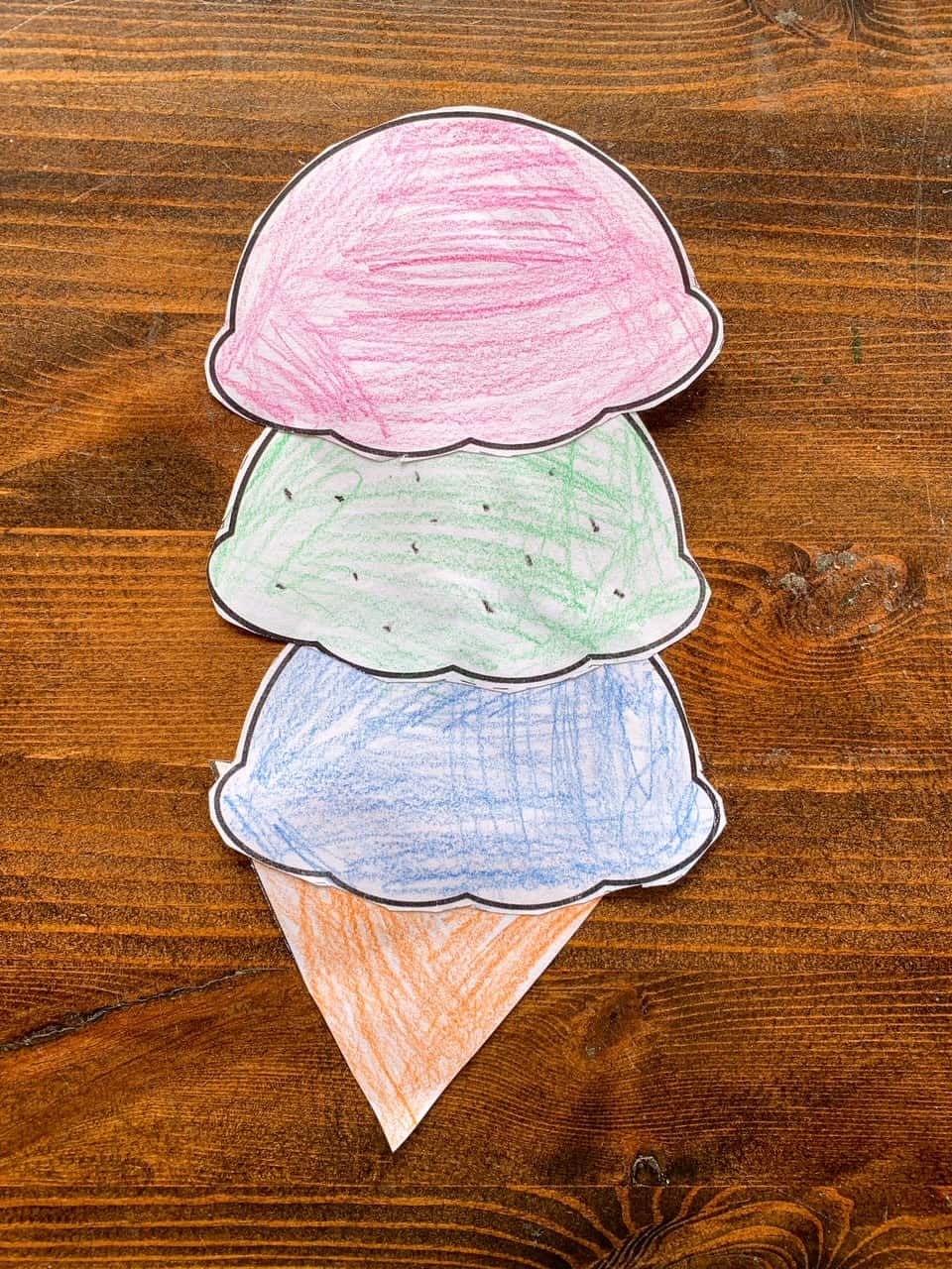 A completed cut and paste ice cream craft with three scoops of ice cream