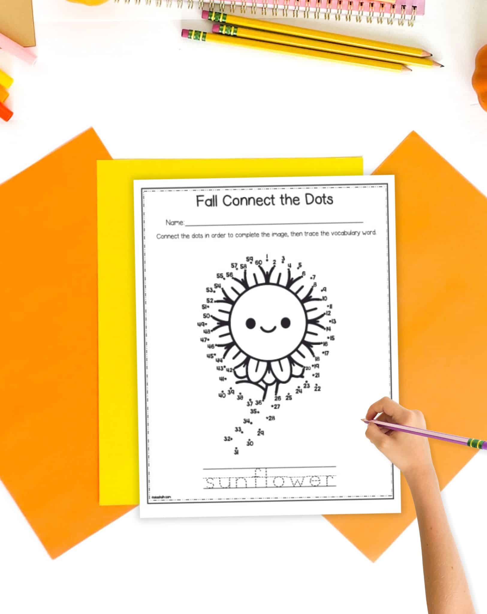 An sunflower connect the dots page on a desk with fall colored school supplies