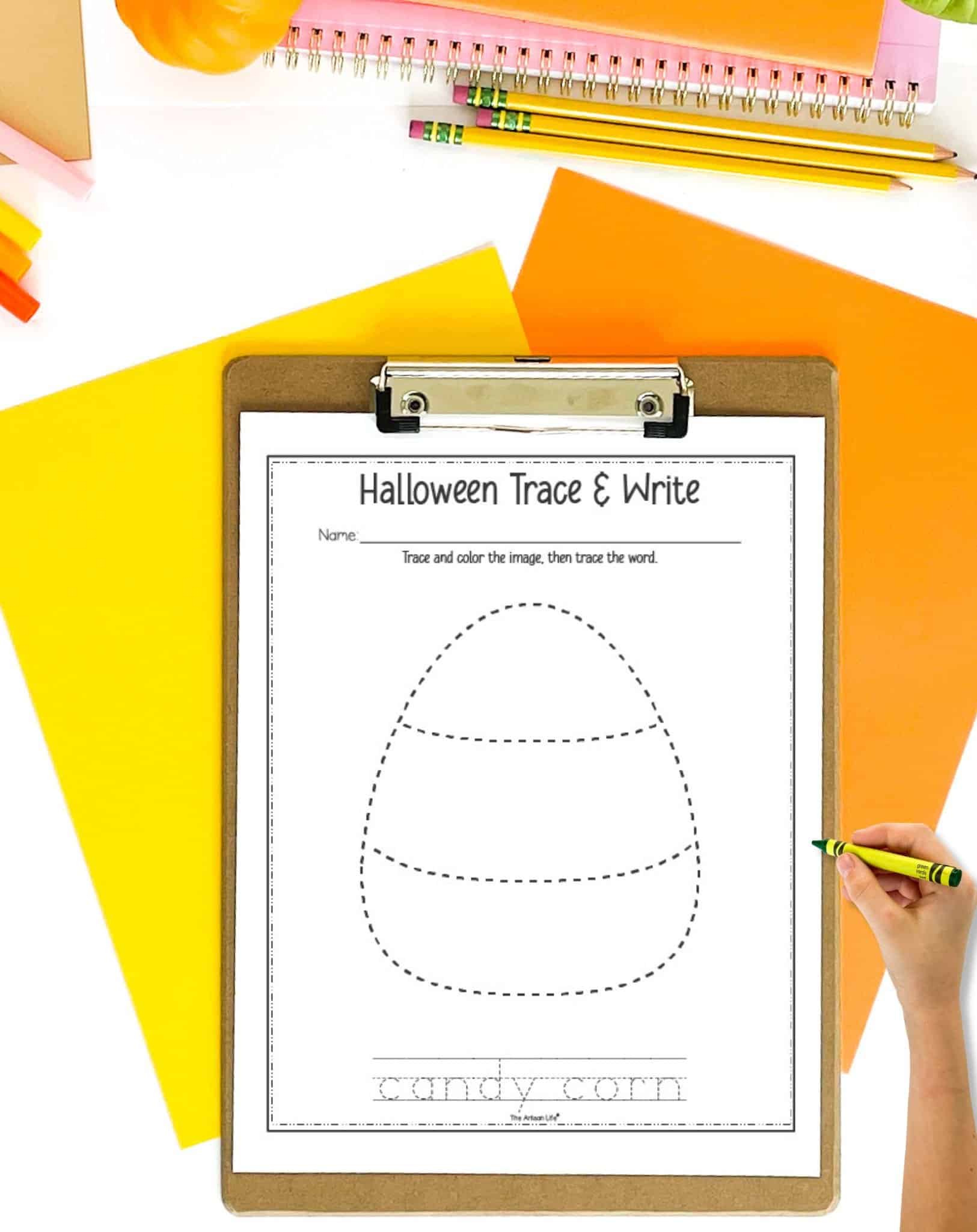 A clip board with a Halloween tracing page showing a candy corn