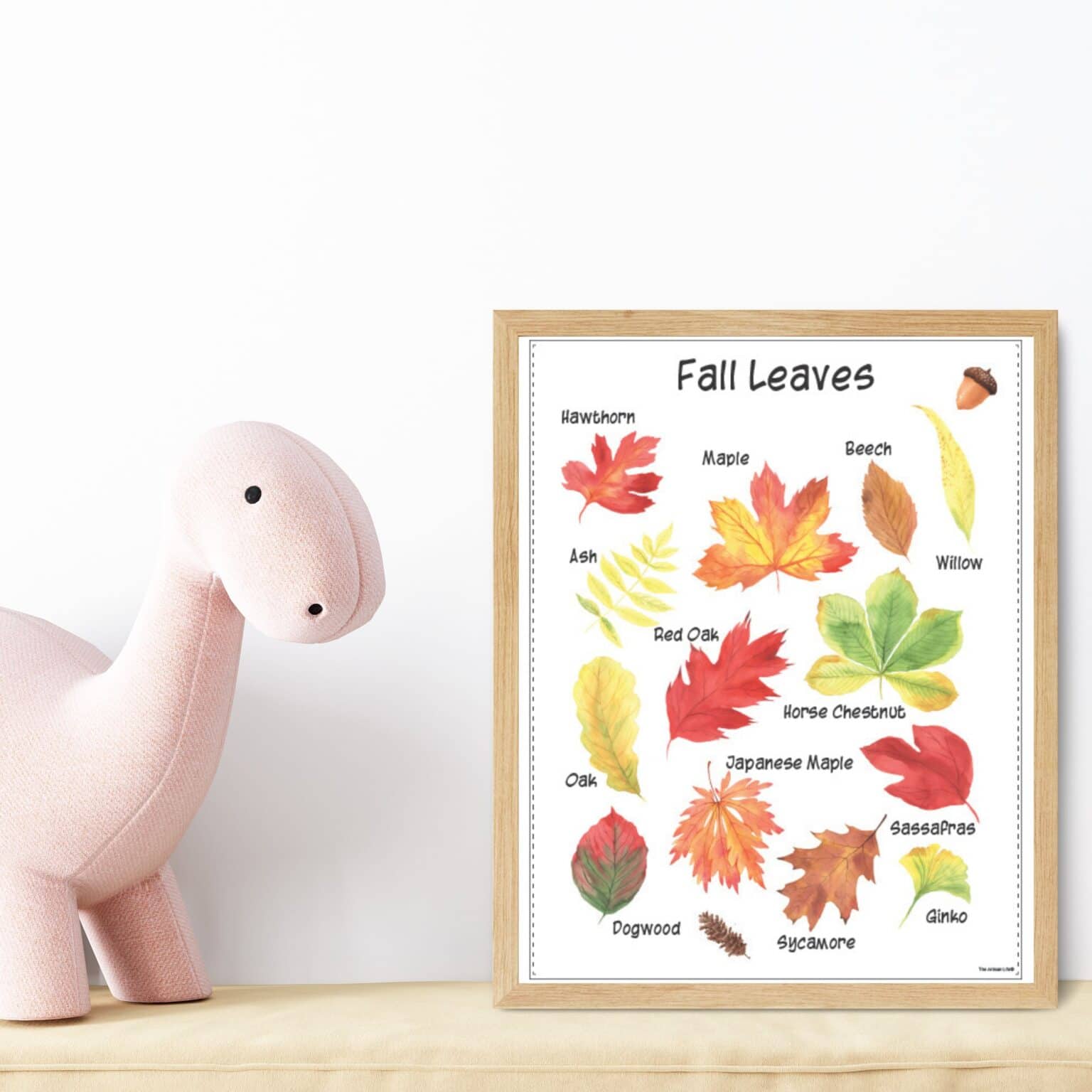 A fall leaves identification poster in a wood frame next to a stuffed dinosaur