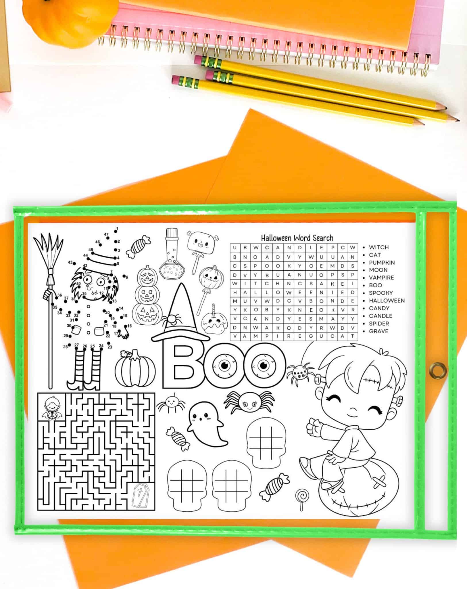 A halloween activity placemat in a dry erase pocket on a d desk with orange papers