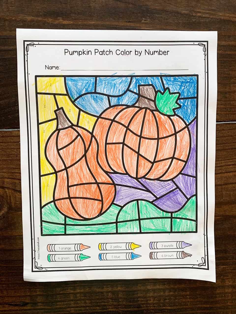 A completed pumpkin patch color by number page colored in by a child with colored pencils