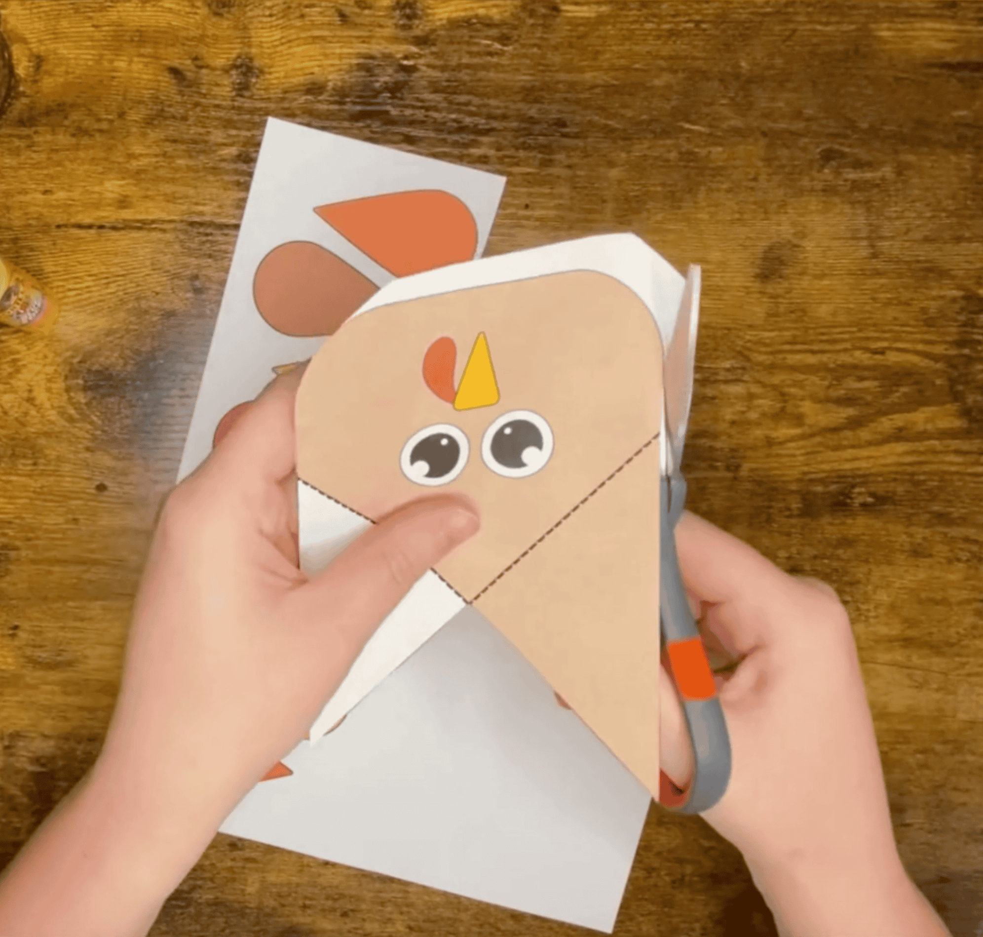 Hands with scissors cutting out a turkey for a turkey corner bookmark craft