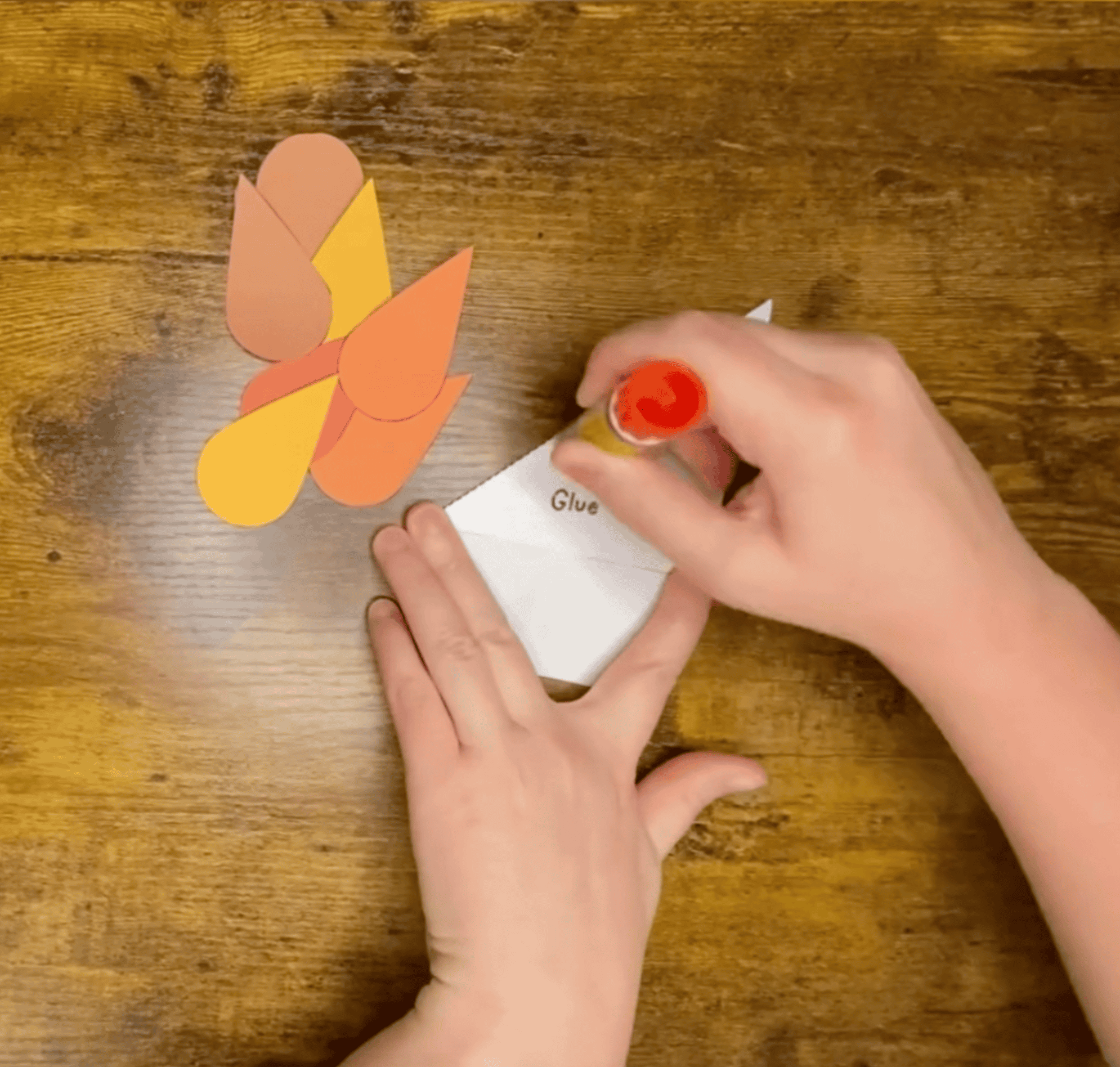 Gluing the pieces of a turkey bookmark craft together