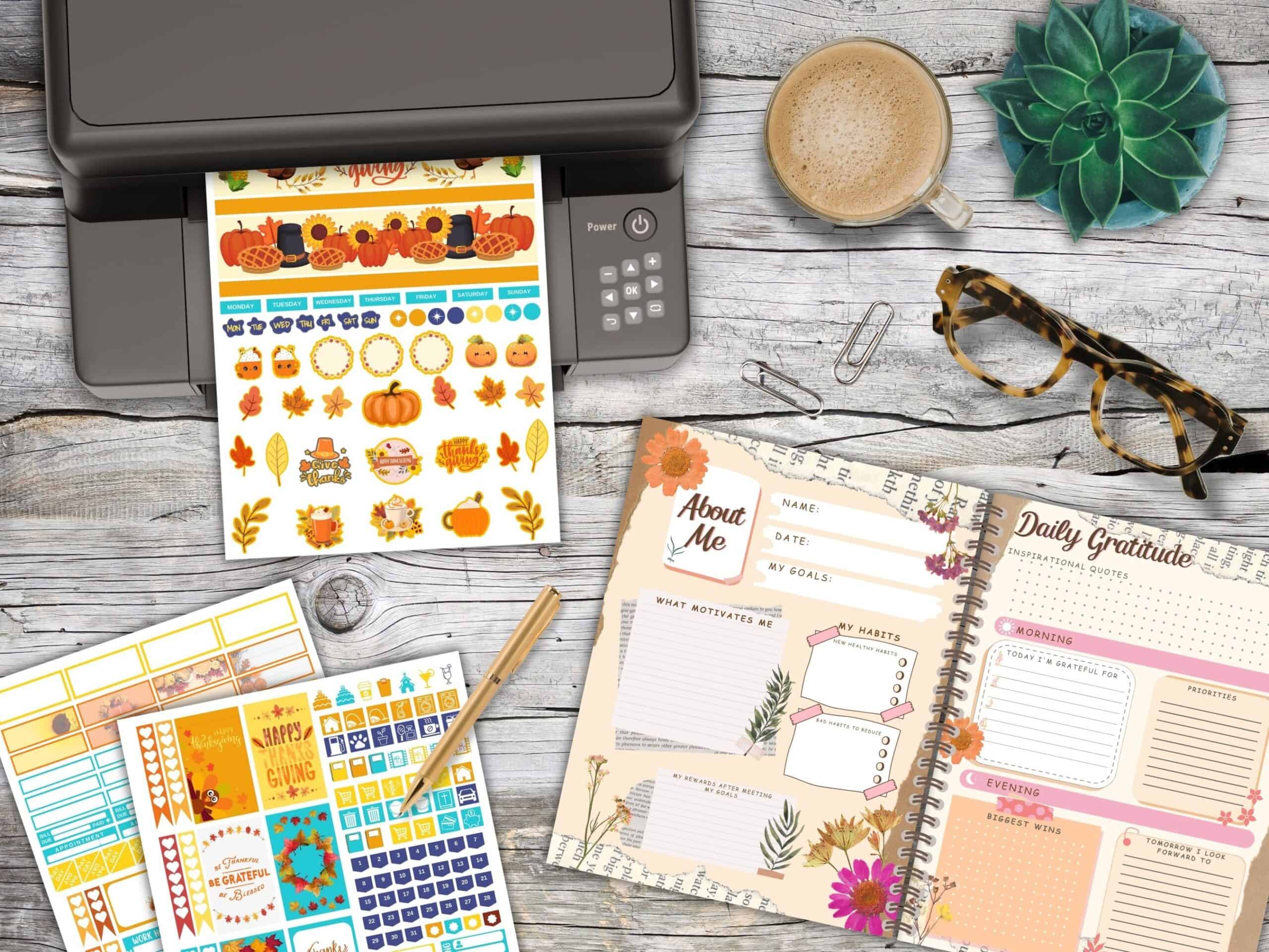 A mockup of a desk with a printer printing Thanksgiving planners tickers. A gratitude journal is open on the desk.