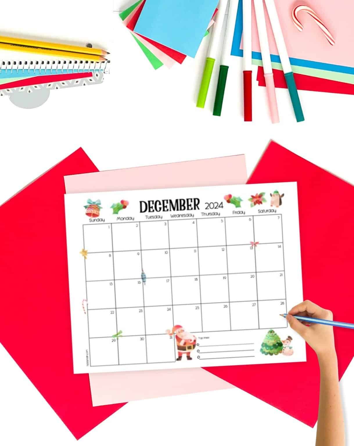 A December 2024 calendar on a table with Christmas stationary supplies