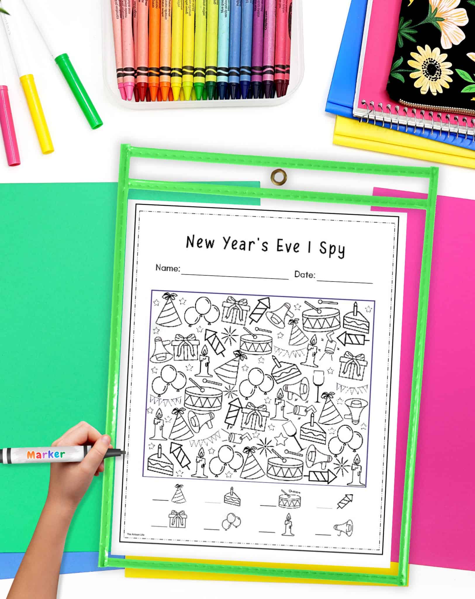 a new year's eve I spy worksheet in a dry erase pocket on a table with colorful papers