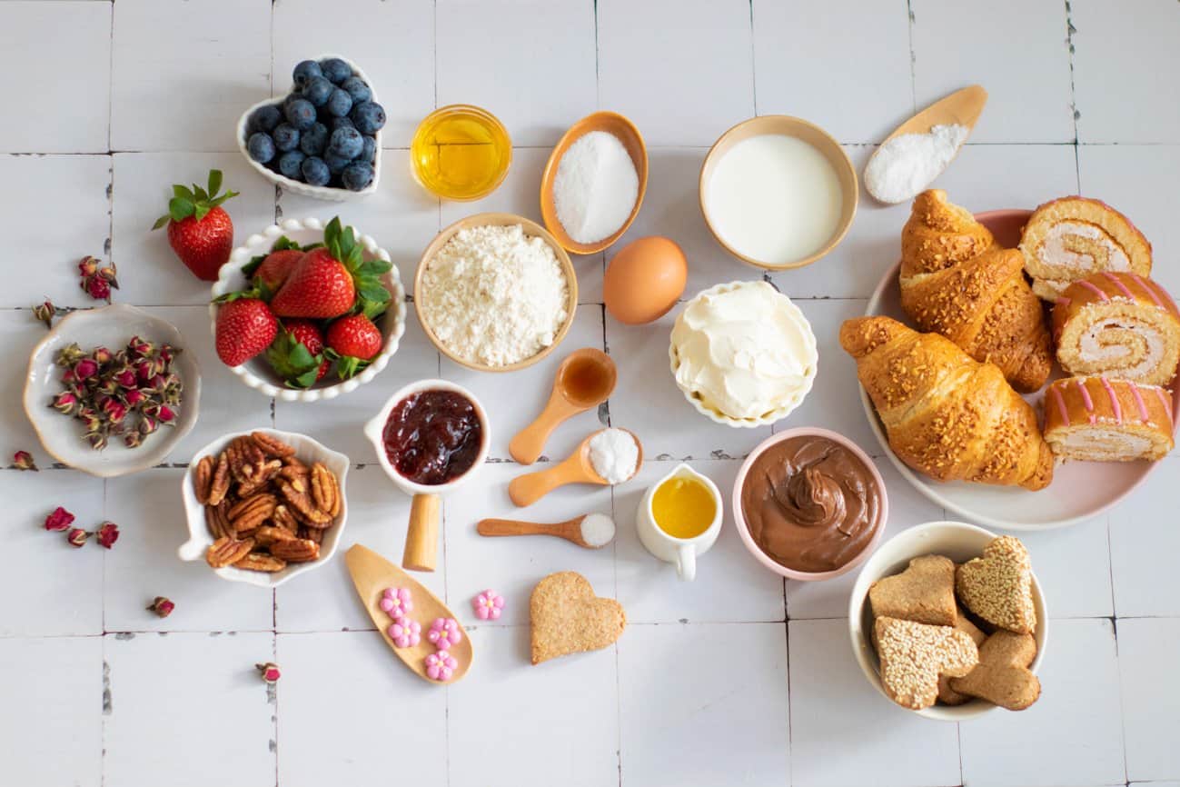 Ingredients for a Valentine's Day or Mother's Day breakfast board including fresh fruit, waffle ingredients, and pastries