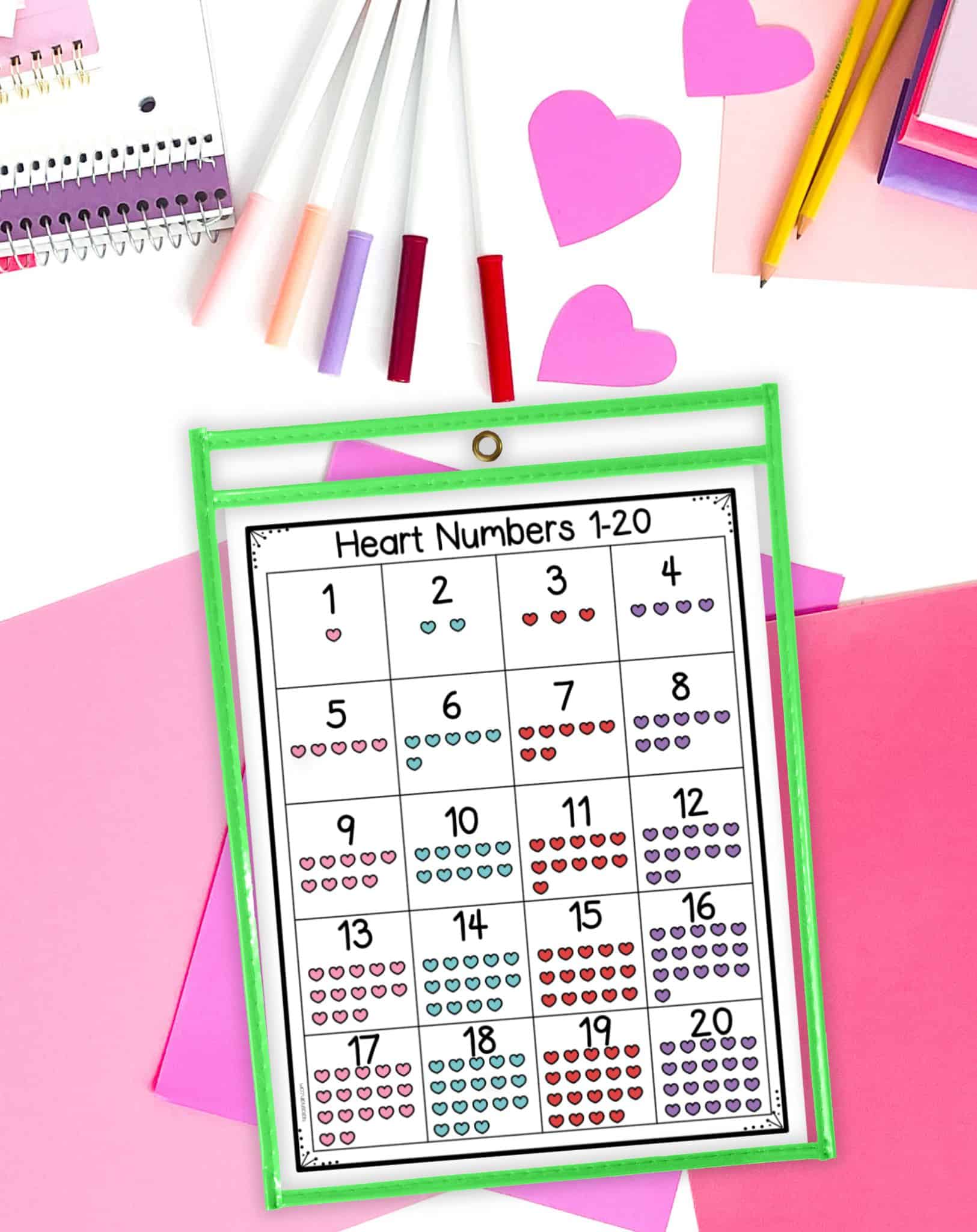 an image of a heart numbers chart 1-20 in a dry erase pocket on a desk with pink papers