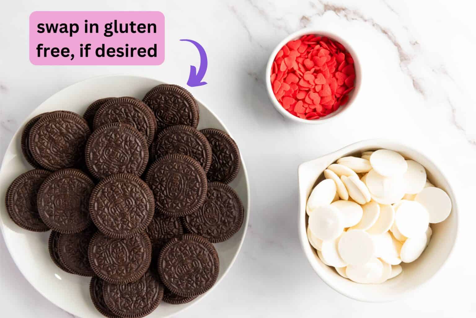 a plate of chocolate sandwich cookie with a bowl of red sprinkle hearts and a bowl of white chocolate chips