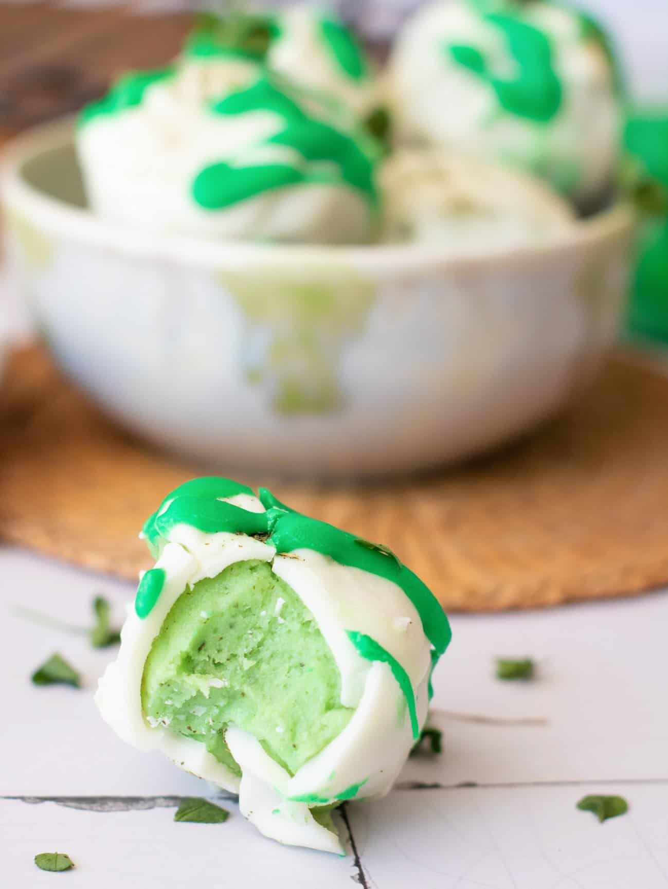 eating a no. bake gluten free truffle ball with white chocolate coating and green chocolate drizzle 