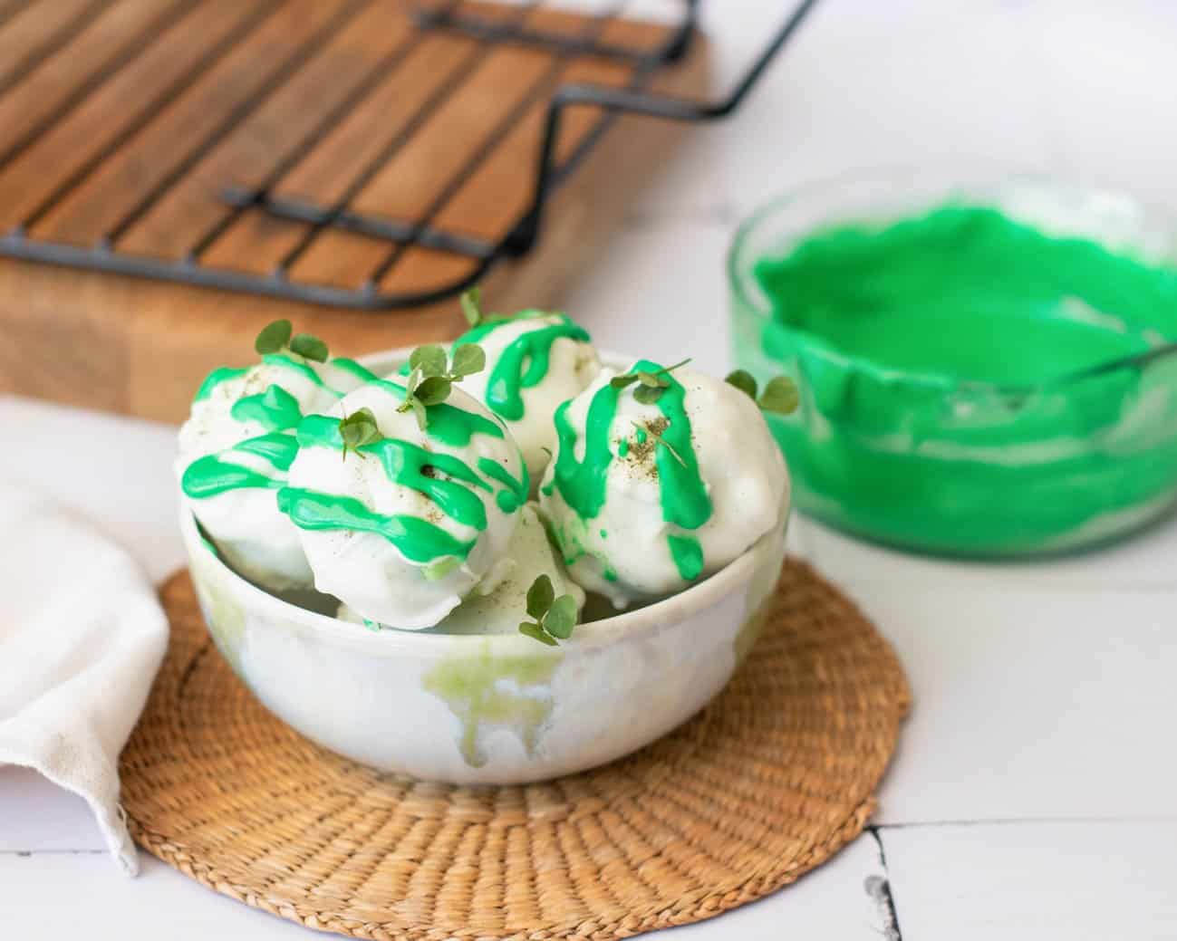 a bowl of gluten free, no bake truffle balls with clover leaves