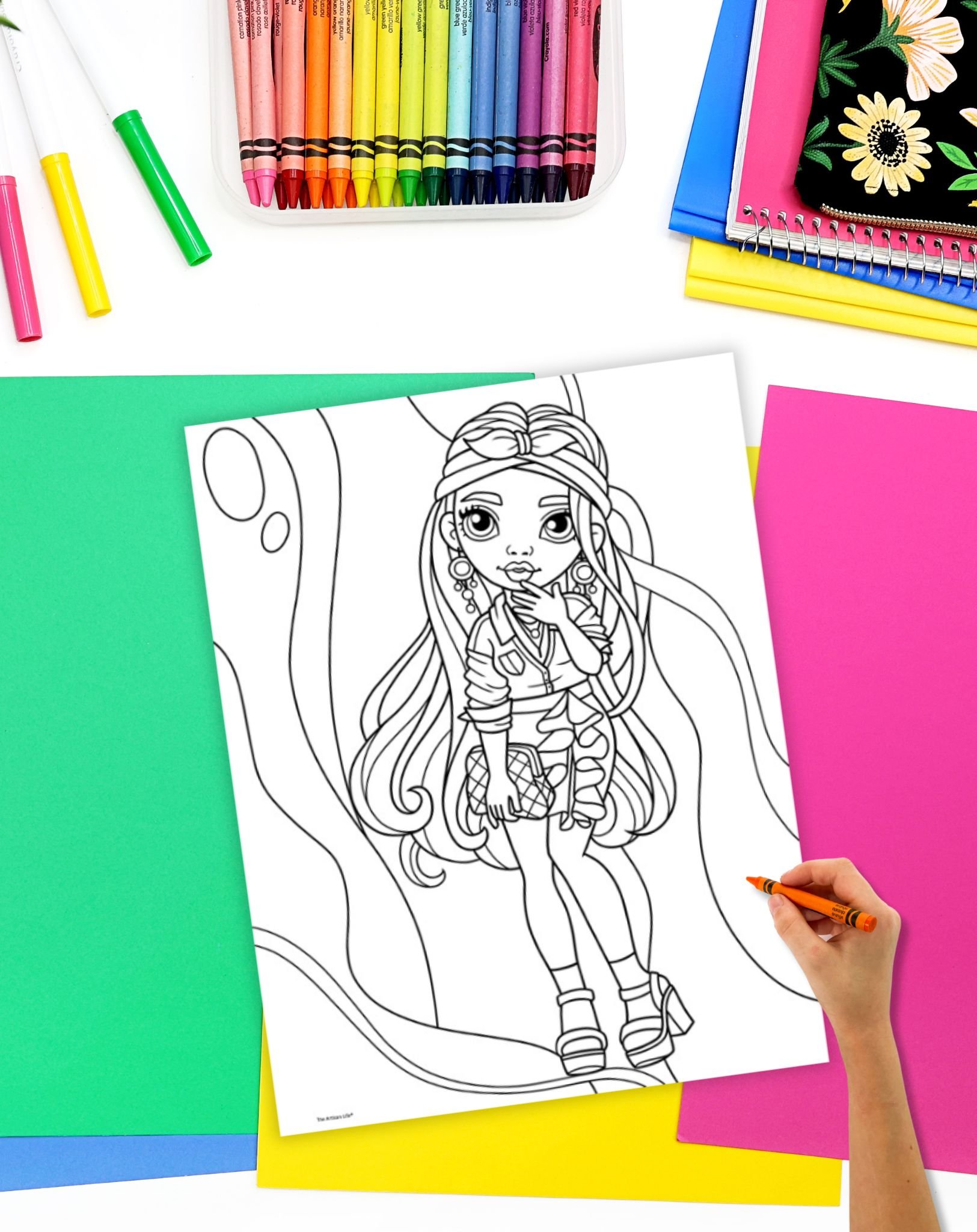 a coloring page showing a girl with long hair and a short skirt on a desk with colorful papers and crayons