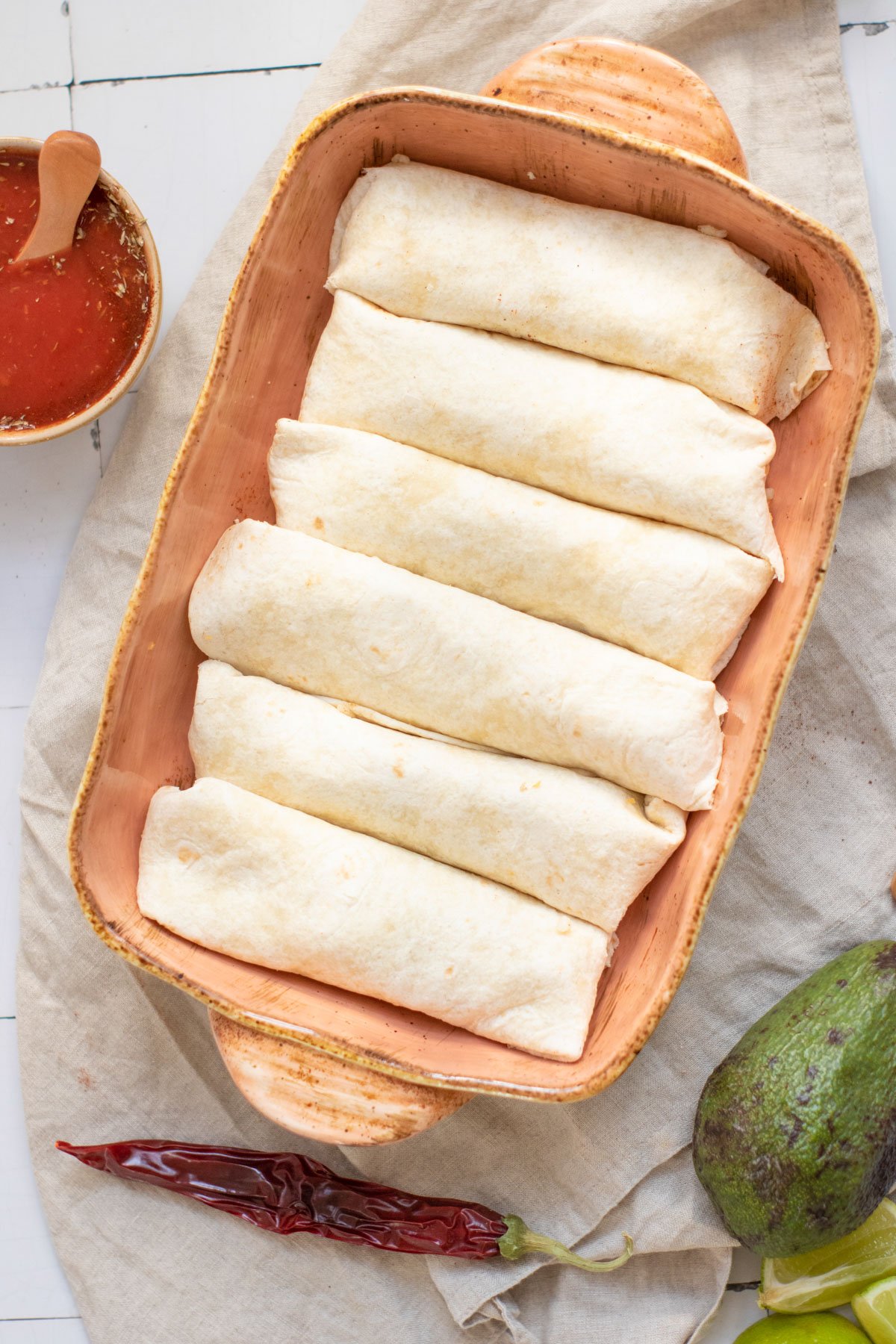 a dish filled with filled enchiladas ready to add sauce and bake