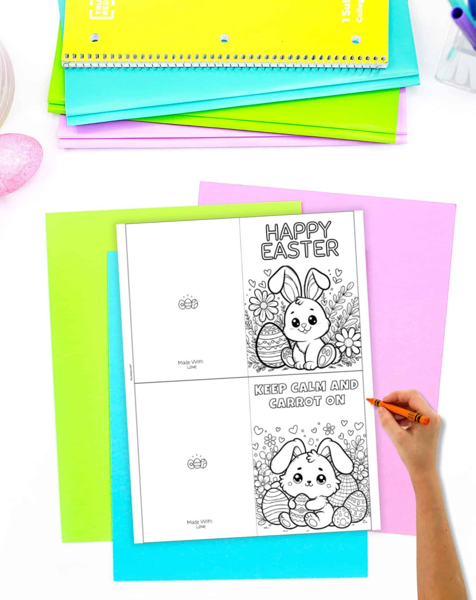 A hand colored in orange is filling in a printable Easter card featuring a "Happy Easter" message and a cute bunny design, placed on vibrant colored paper with additional paper and a decorative egg nearby, suitable for homemade Easter cards and simple crafts for kids.
