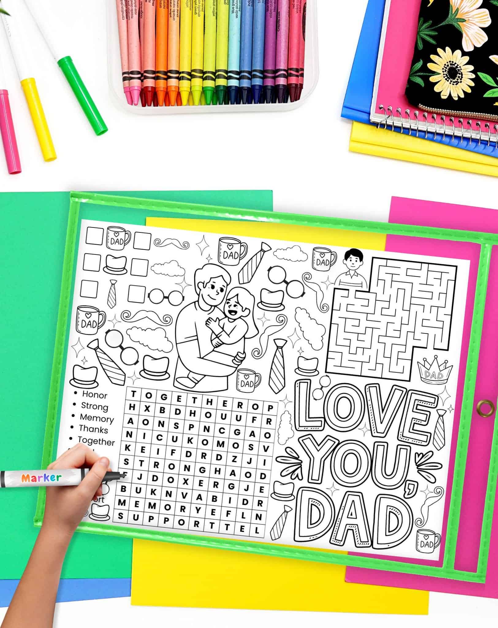 A child's hand using a marker to complete a Father's Day activity placemat printable