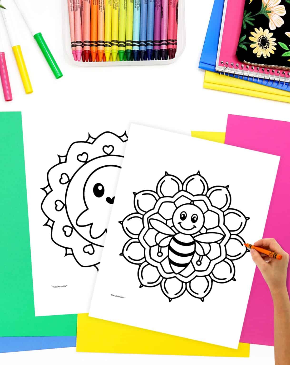 The image features two easy mandala coloring pages for toddlers, one depicting a smiling bee and the other a cute character, with a selection of crayons and colorful papers surrounding them.