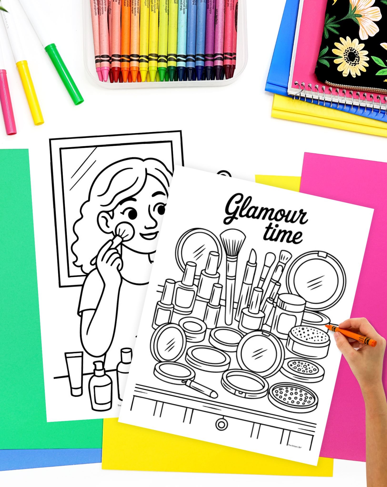 A hand colors a black-and-white makeup-themed coloring page titled "Glamour time," featuring various cosmetics and tools, alongside vibrant coloring supplies and colored paper.
