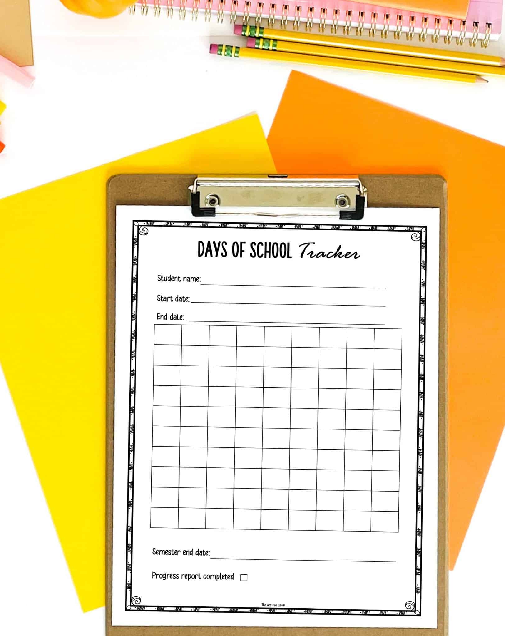 A clipboard holds a "Days of School Tracker" sheet designed for homeschool attendance tracking, featuring sections for student name, start and end dates, and a grid for marking attendance, surrounded by colorful stationery.
