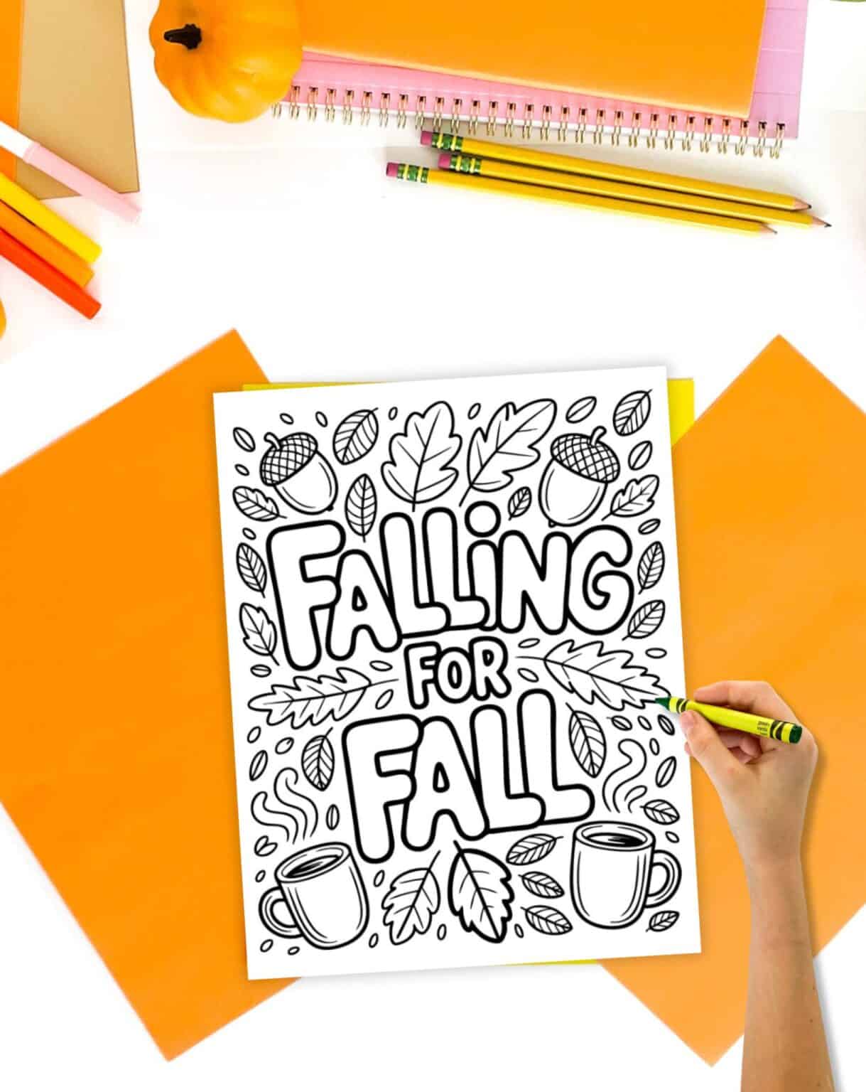 A hand with a crayon and a coloring page with the quote "falling for fall"