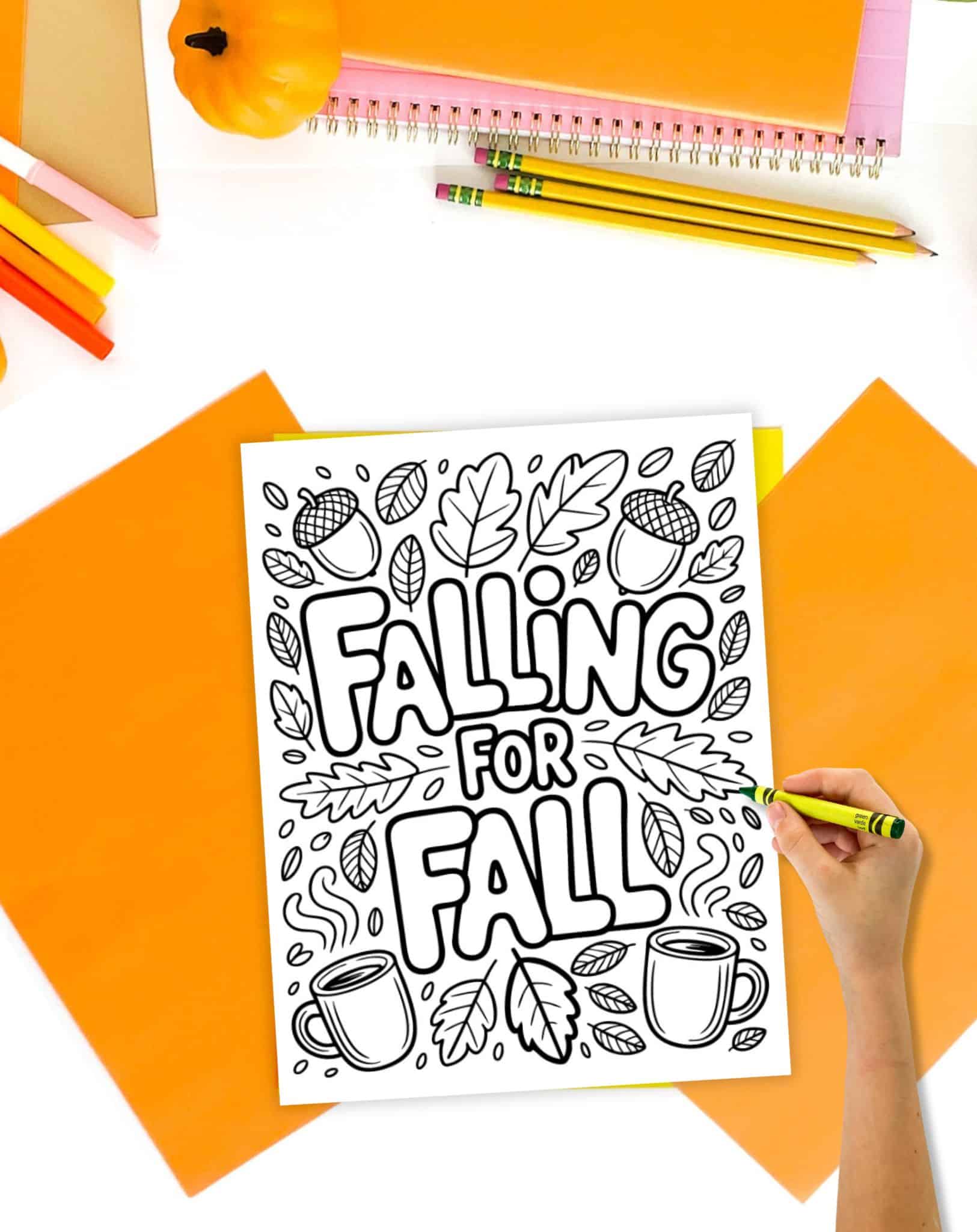 A hand with a crayon and a coloring page with the quote "falling for fall"