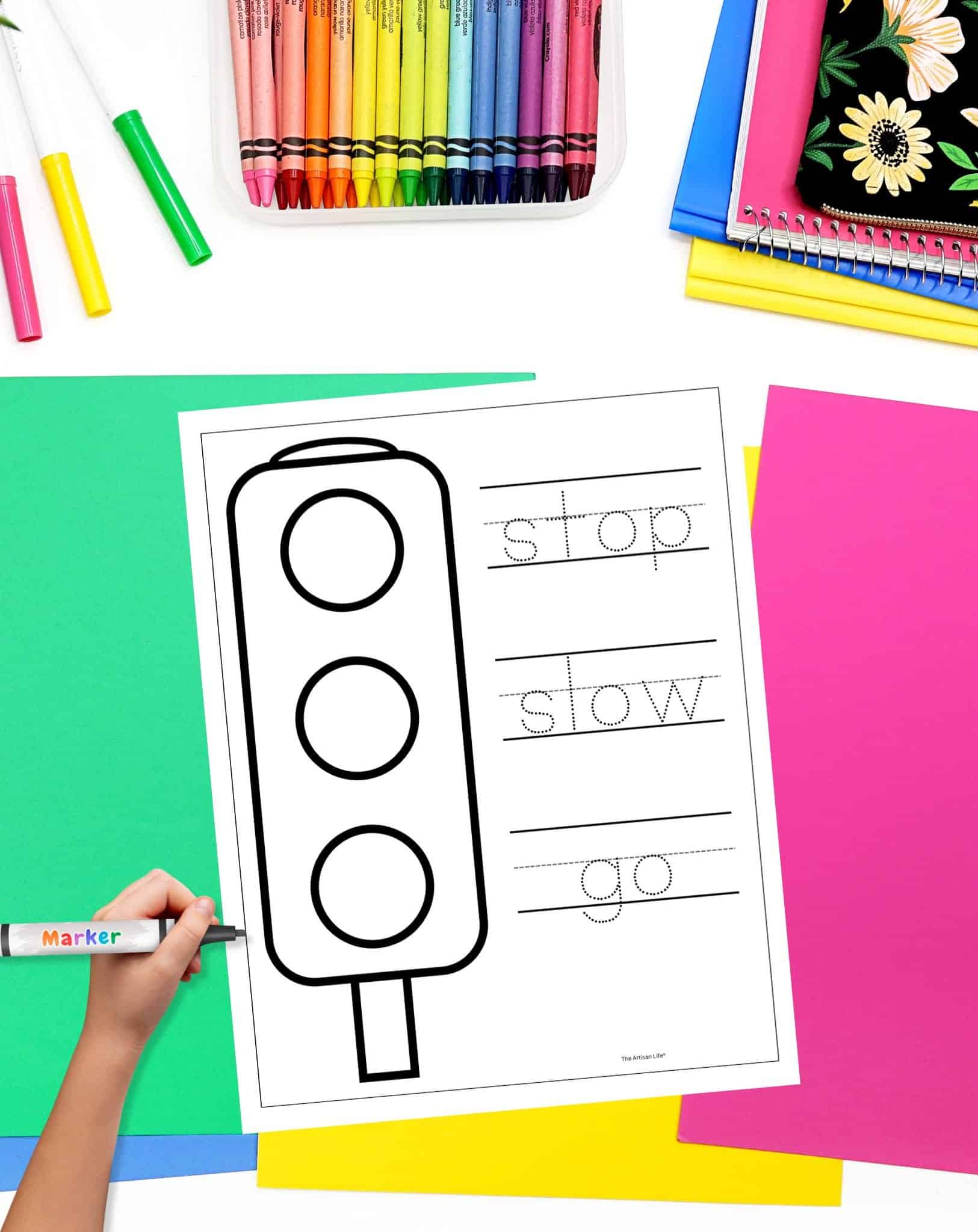 a traffic light safety coloring page on a desk with colorful papers