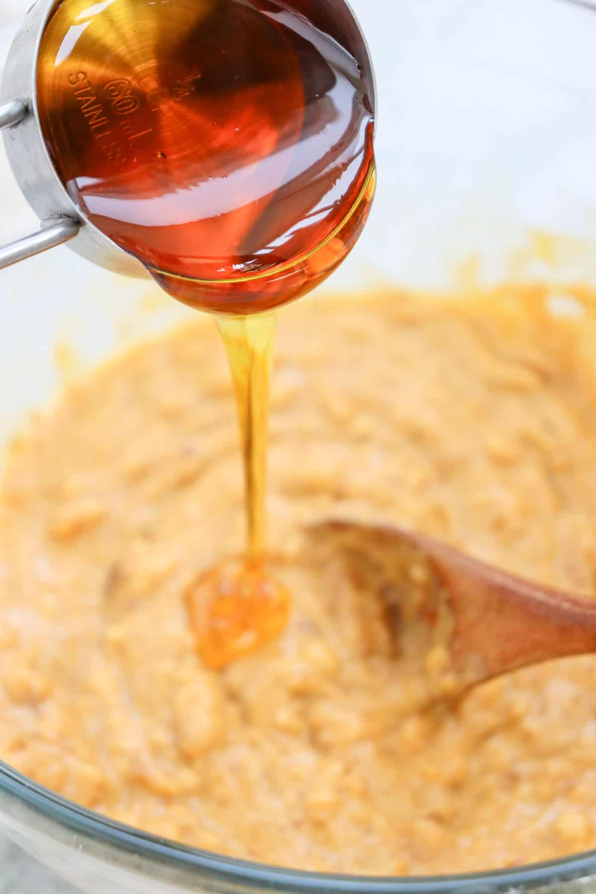 pouring in maple syrup for sweet potato brownies