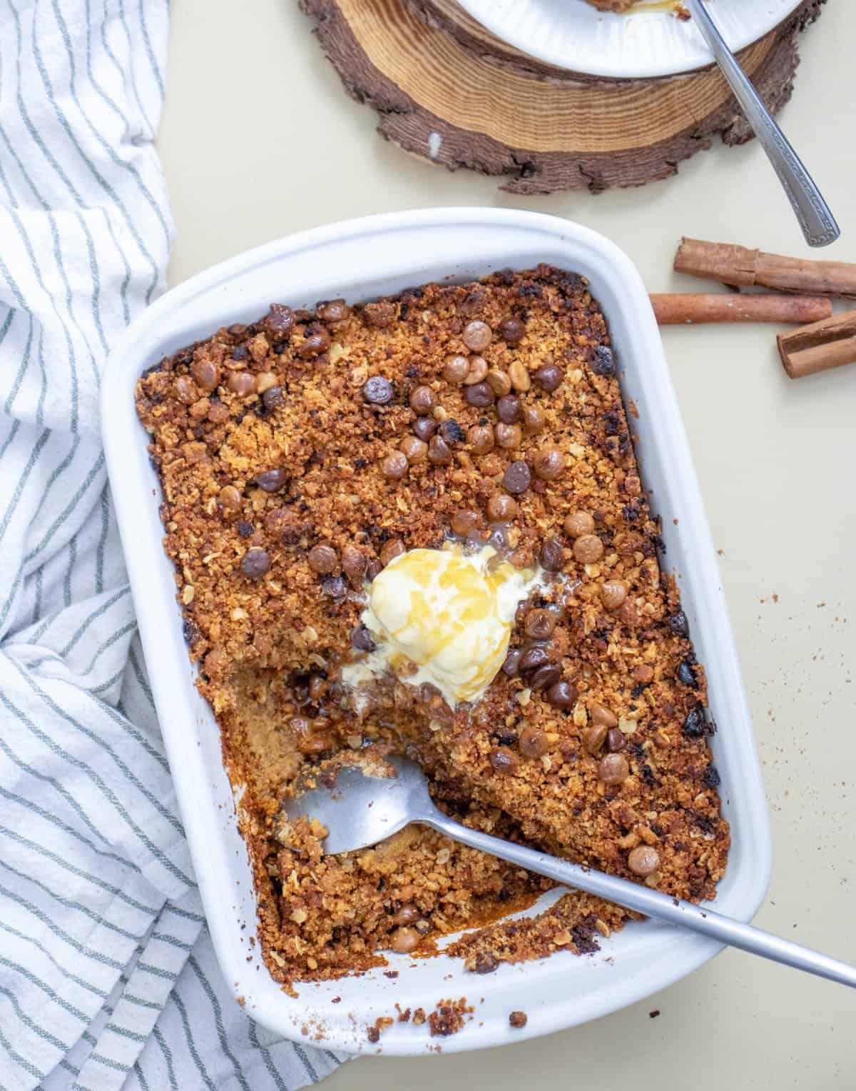 a baking dish with baked pumpkin crisp with ice cream in the middle