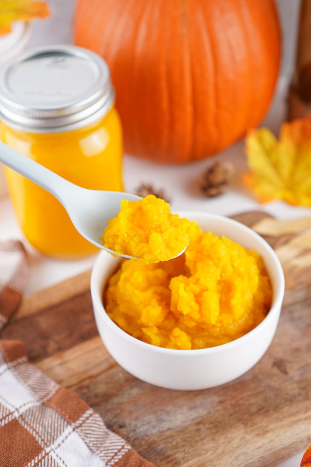 a spoon scooping out a small amount of homemade pumpkin puree