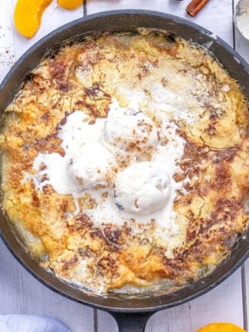 A peach dump cake in a cast iron skillet