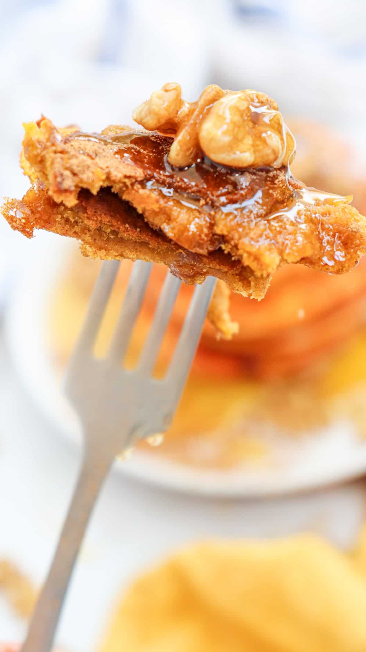 A fork with a bite sized piece of pumpkin pancakes for fall
