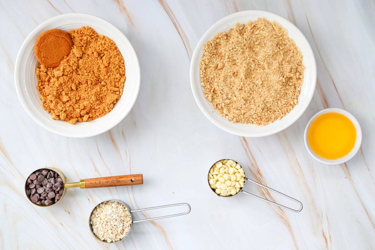 Ingredients for an easy pumpkin crisp recipe are arranged on a marble countertop, including canned pumpkin, eggs, brown sugar, and spices.
