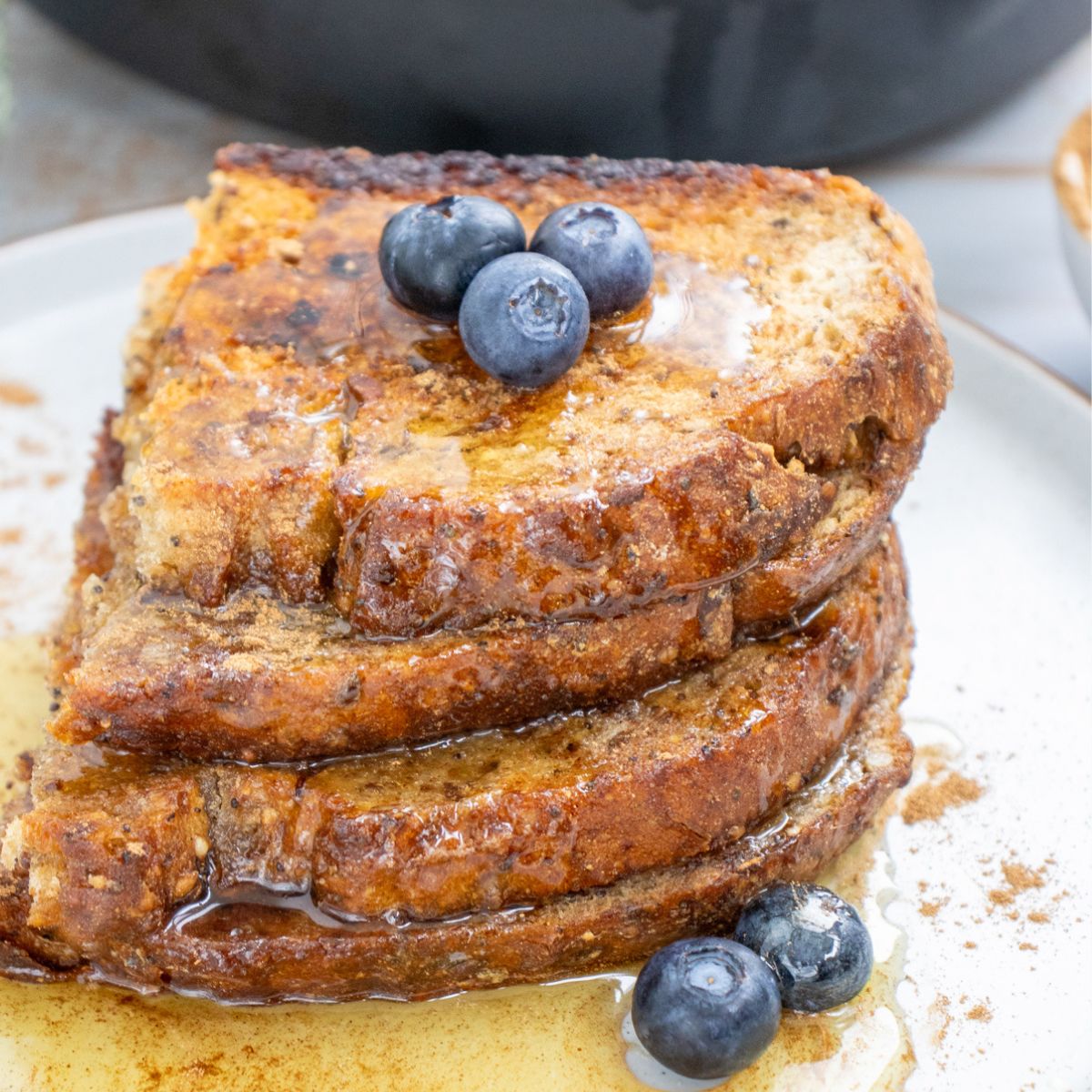 a stack of sourdough toast with maple syrup and blueberries