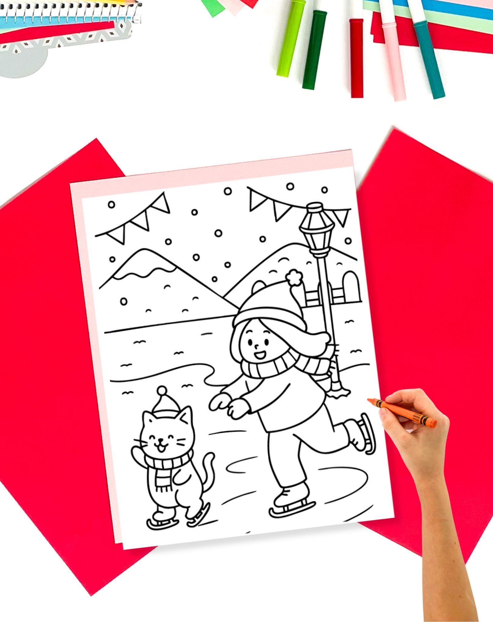 A coloring page showing a girl and a cat ice skating on a table with colorful stationary supplies