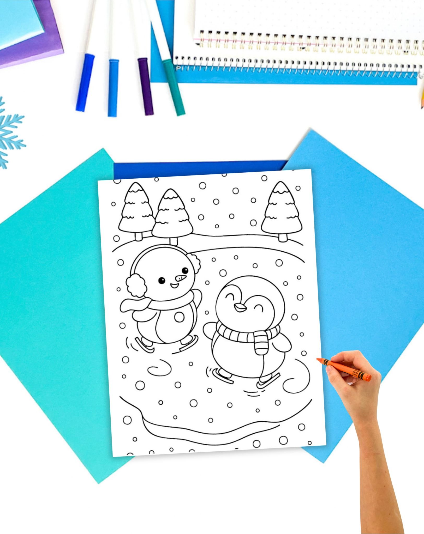 a child's hand coloring a coloring s sheet showing a snowman and a penguin ice skating on a pond