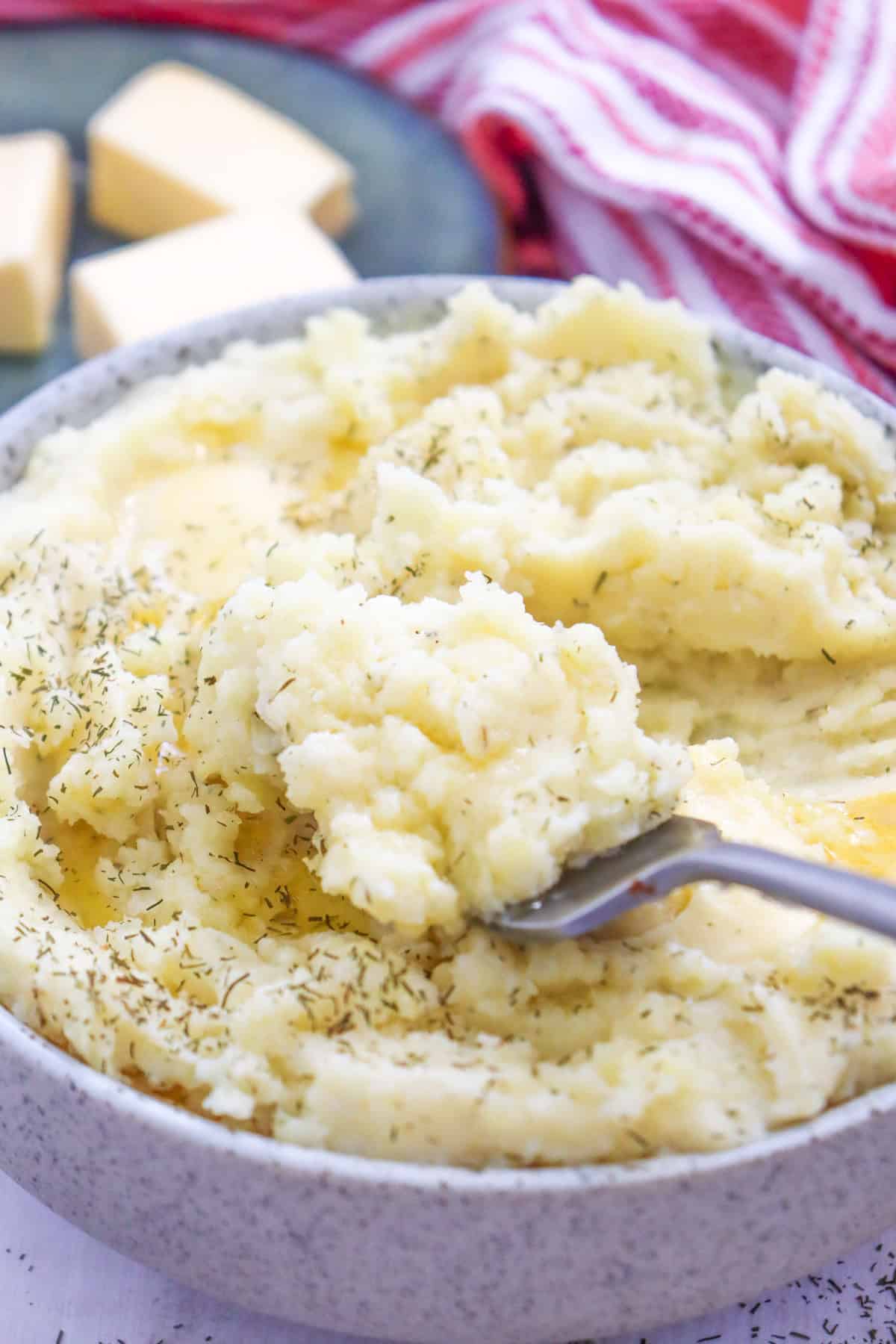 a spoon scooping herbed mashed potatoes