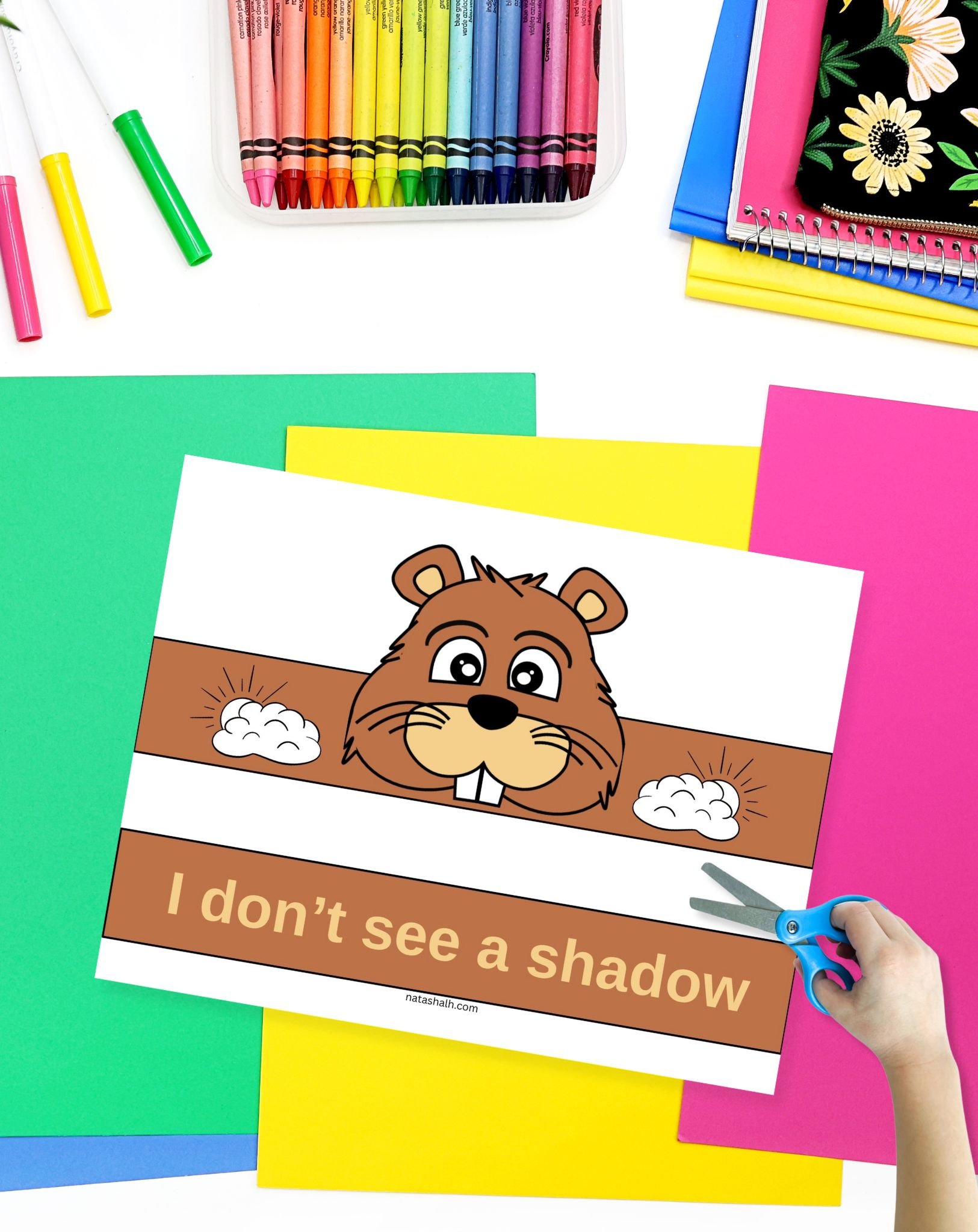 a child with a pair of scissors preparing to cut out a Groundhog Day crown craft