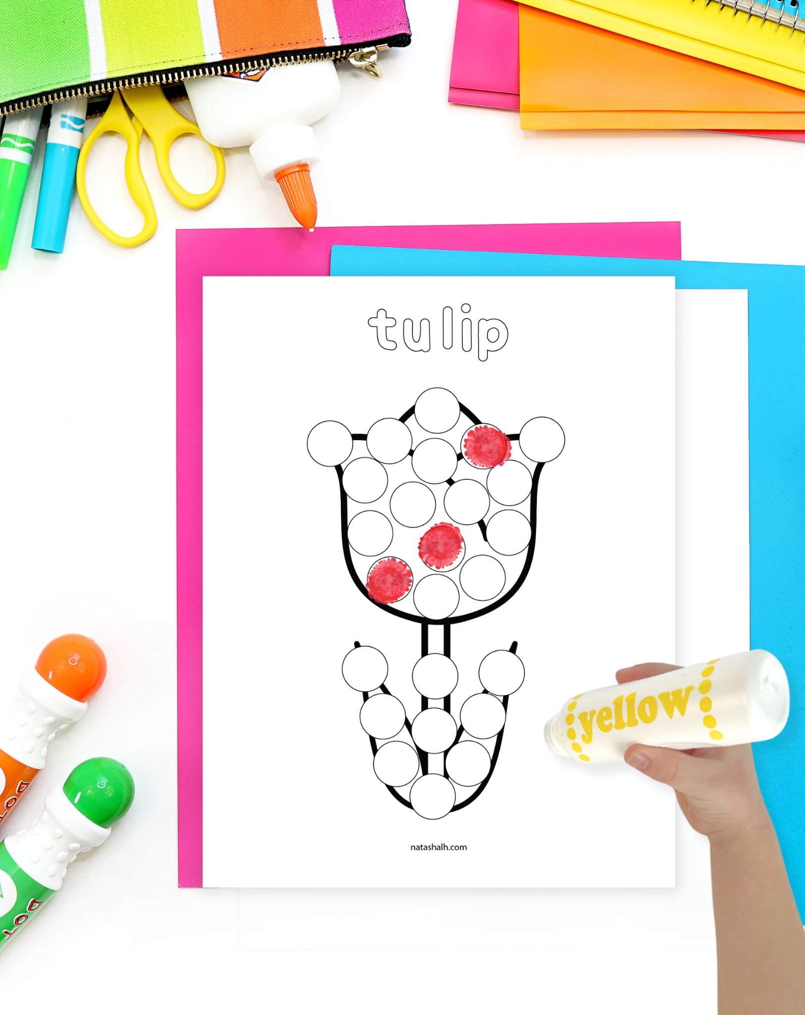 a chid's hand dot marker preparing to use a spring flower dot marker coloring pages