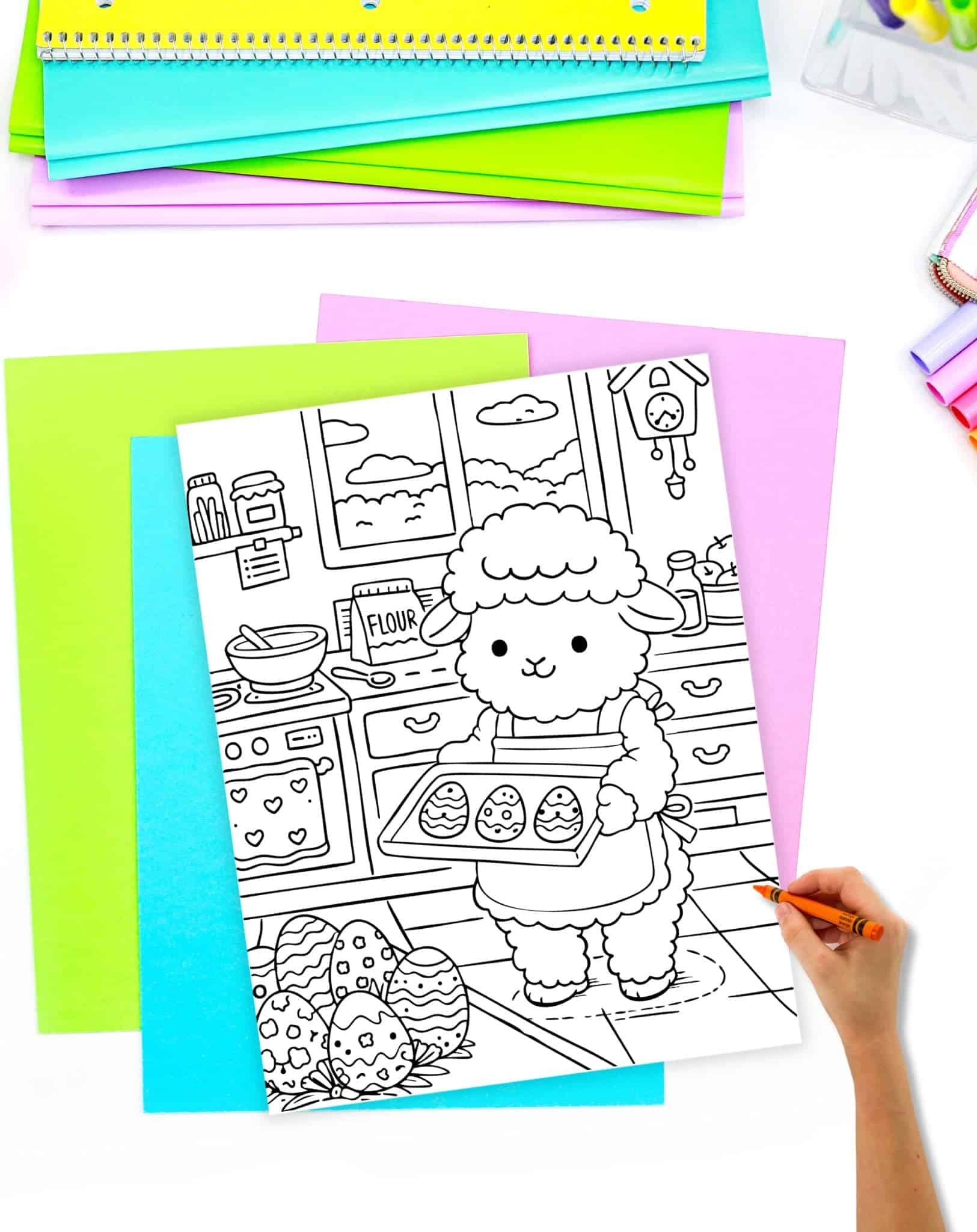 a hand preparing to color a coloring page showing a lamb baking easter cookies