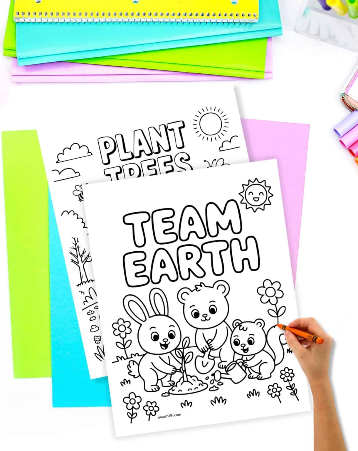 a child's hand holding an orange crayon preparing to color a coloring page with animals gardening and "team earth" in a bubble font